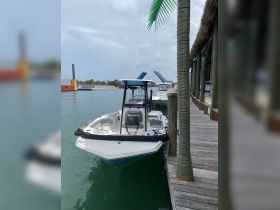 A sleek center console boat docked at a marina, showcasing its clean lines and inviting design, perfect for a day on the water.