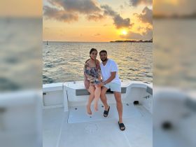 A couple enjoys a romantic moment on a boat at sunset, creating the perfect backdrop for memorable celebrations on the water.