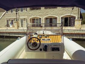 A detailed view of the helm and console inside a boat, showcasing the steering wheel and control panel, perfect for navigating the waters.