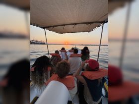 A group of friends enjoys a picturesque sunset on a boat, creating a perfect backdrop for memorable moments on the water.