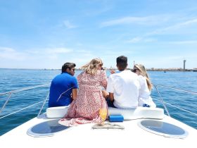 A group of friends enjoys a sunny day on a yacht, sipping cocktails and taking in the beautiful ocean views — perfect for a memorable outing on the water.