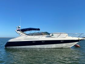 A sleek yacht docked in calm waters, showcasing its elegant design against a clear blue sky — perfect for luxury boating experiences.