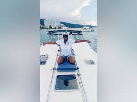 A joyful individual poses as the captain on a boat, showcasing the fun and excitement of a day on the water.