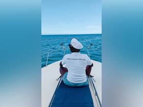 A person enjoys the serene ocean view from the bow of a boat, embodying the spirit of freedom on the water.