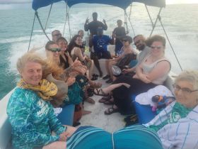 A lively group enjoys a boat ride, capturing moments of fun and camaraderie on the water — perfect for snorkeling adventures or group outings.