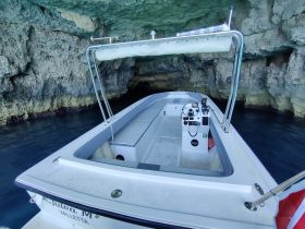 Interior view of a boat's helm and cabin area, showcasing the console and seating, perfect for navigating through scenic waters.