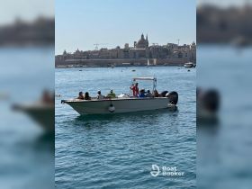 A lively group enjoys a day on the water aboard a boat, with a stunning cityscape in the background — perfect for exploring coastal destinations.
