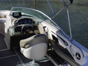 An interior view of a boat's helm showcasing the steering console and seating area, perfect for navigating the waters in style and comfort.