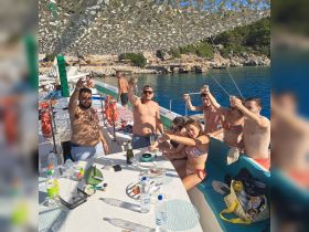 A lively group celebrates aboard a boat, raising their glasses in a toast while enjoying a sunny day on the water — perfect for parties and gatherings.