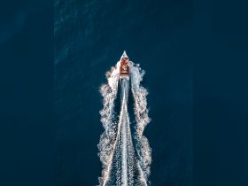 Aerial view of a speedboat cruising through deep blue waters, showcasing the thrill of boating adventures on the open sea.