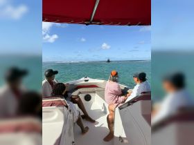 A group of friends enjoys a scenic boat ride, taking in the beautiful ocean views and relaxing together on the water.