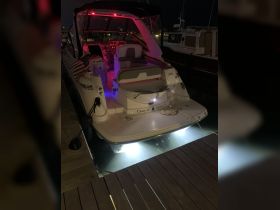 The interior of the 'Casey IV' boat is illuminated with vibrant lighting, showcasing the helm and seating area, perfect for nighttime cruising.