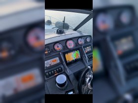 A detailed view of the helm and console of a boat, showcasing navigation instruments and controls, ideal for understanding the vessel's operation.