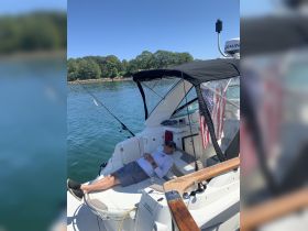 A man relaxes on the deck of a boat, enjoying a sunny day on the water — perfect for fishing or leisurely outings.