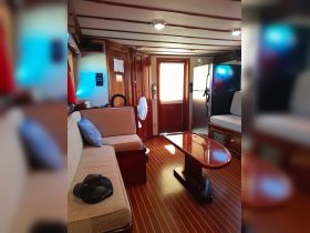 Interior view of a cozy boat cabin featuring comfortable seating and modern amenities, perfect for relaxing during your nautical adventures.