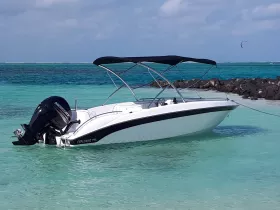 A sleek speedboat named 'Explorer 115' anchored in clear turquoise waters, perfect for a day of adventure on the sea.