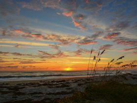 A stunning sunset over the beach, with vibrant colors reflecting on the water — a perfect backdrop for evening boat trips or coastal adventures.