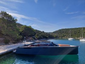A sleek yacht docked in a serene bay, surrounded by lush greenery and calm waters, perfect for a relaxing getaway.