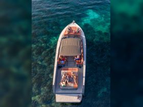 A lively group enjoys a day on the water aboard a stylish boat, relaxing and sipping cocktails while surrounded by crystal-clear waters — perfect for summer fun and celebrations.