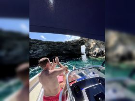 A group of friends enjoys a scenic boat ride, capturing the stunning rock formations and clear waters — perfect for adventure seekers exploring hidden gems.