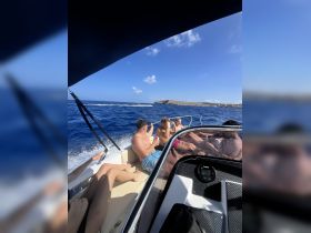 A lively group enjoys a sunny day on the water, capturing the essence of fun and adventure aboard their boat.
