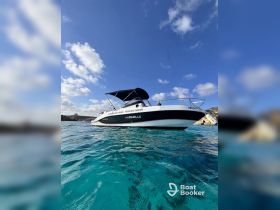 A sleek Marinello speedboat glides through crystal-clear waters, perfect for private charters and leisure cruises under the sunny sky.