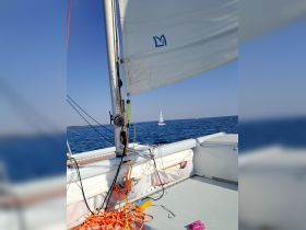 A close-up view of a sailboat's rigging and sail while underway, showcasing the beauty of sailing on open waters.