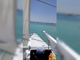 A stunning view from the deck of a catamaran, showcasing the clear turquoise waters and surrounding boats, perfect for a day of sailing and exploration.