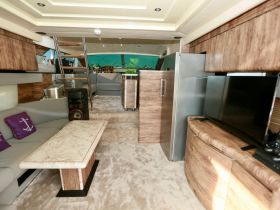 Interior view of a luxurious boat cabin featuring comfortable seating and modern amenities, perfect for relaxing while cruising on the water.