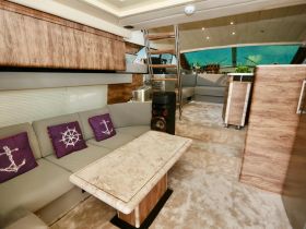 Interior view of a luxurious boat cabin featuring comfortable seating and stylish decor, perfect for relaxing during a day on the water.