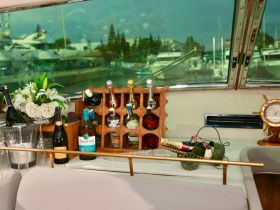 A beautifully arranged bar area on a boat featuring a selection of fine spirits and champagne, perfect for entertaining guests while enjoying a day on the water.