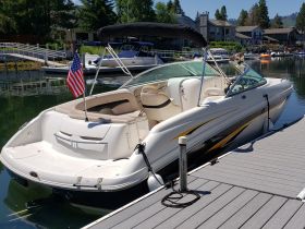 A sleek speedboat docked at a marina, showcasing its elegant design and American flag — perfect for summer outings on the water.
