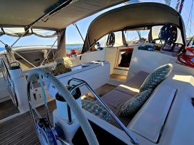 A cozy interior view of a sailboat's helm and seating area, showcasing comfortable cushions and a well-equipped space for relaxation on the water.