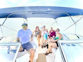 A lively group of friends enjoys a day on the boat, capturing the essence of fun and camaraderie on the water.