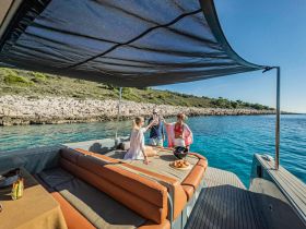 A lively group enjoys drinks and snacks aboard a stylish boat, perfect for celebrations and social gatherings on the water.