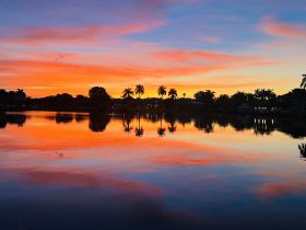 A stunning sunset reflects on calm waters, creating a picturesque scene perfect for evening boat trips or relaxation by the shore.