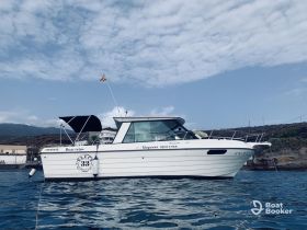 A sleek boat is docked in calm waters, showcasing its elegant design against a scenic backdrop — perfect for boat trips and excursions.