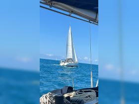 A beautiful sailing scene captures a yacht underway in the ocean, showcasing the joy of boating and the stunning blue waters.