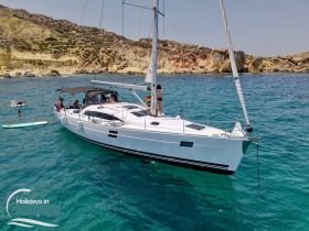 A lively group enjoys a day of sailing and swimming around a stunning yacht in crystal-clear waters, perfect for summer adventures.