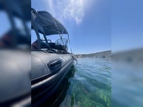 A sleek speedboat captured from the side, gliding through clear waters, showcasing the vibrant underwater scenery — perfect for adventure seekers.