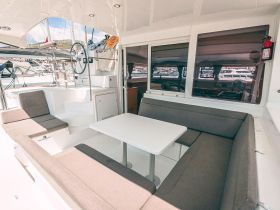 A spacious and modern interior of a boat featuring comfortable seating and a helm area, perfect for relaxing or navigating during a day on the water.