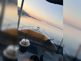 A serene view from inside a boat, showcasing the comfortable seating and a calm waterfront at sunrise — perfect for relaxing outings on the water.