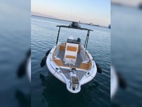 A sleek speedboat anchored at the dock, showcasing its spacious deck and modern design — perfect for day trips and water adventures.