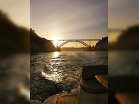 A stunning sunset view of a bridge reflecting on the water, captured from a boat — perfect for scenic cruises and memorable experiences.
