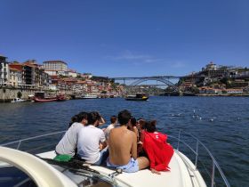 A lively group enjoys a scenic boat ride along the river, taking in the beautiful cityscape and iconic bridge views — perfect for sightseeing and relaxation.