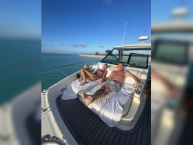 A couple enjoys a relaxing day on the deck of a boat, soaking up the sun and the stunning ocean views — perfect for a romantic getaway.