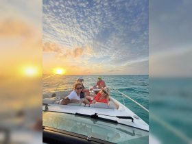 A group of friends enjoys a sunset cruise on a boat, capturing the perfect moment of relaxation and camaraderie on the water.