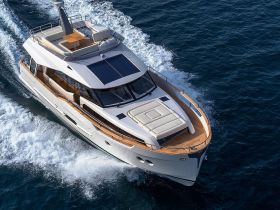 A stunning aerial view of a luxury yacht cruising through the waves, showcasing its elegant design and spacious deck — perfect for upscale boating experiences.