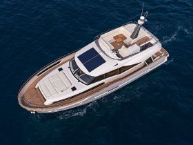 A stunning aerial view of a luxurious yacht cruising through deep blue waters, showcasing its sleek design and spacious deck — perfect for upscale boating experiences.