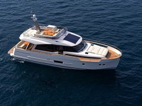 A stunning aerial view of a luxurious yacht cruising through deep blue waters, showcasing its elegant design and spacious deck.